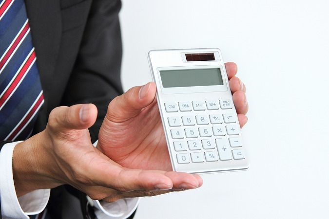 電卓を差し出すビジネスマン